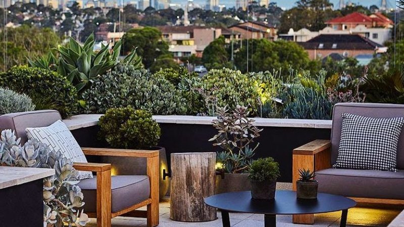 Roof deck with patio furniture and city in background